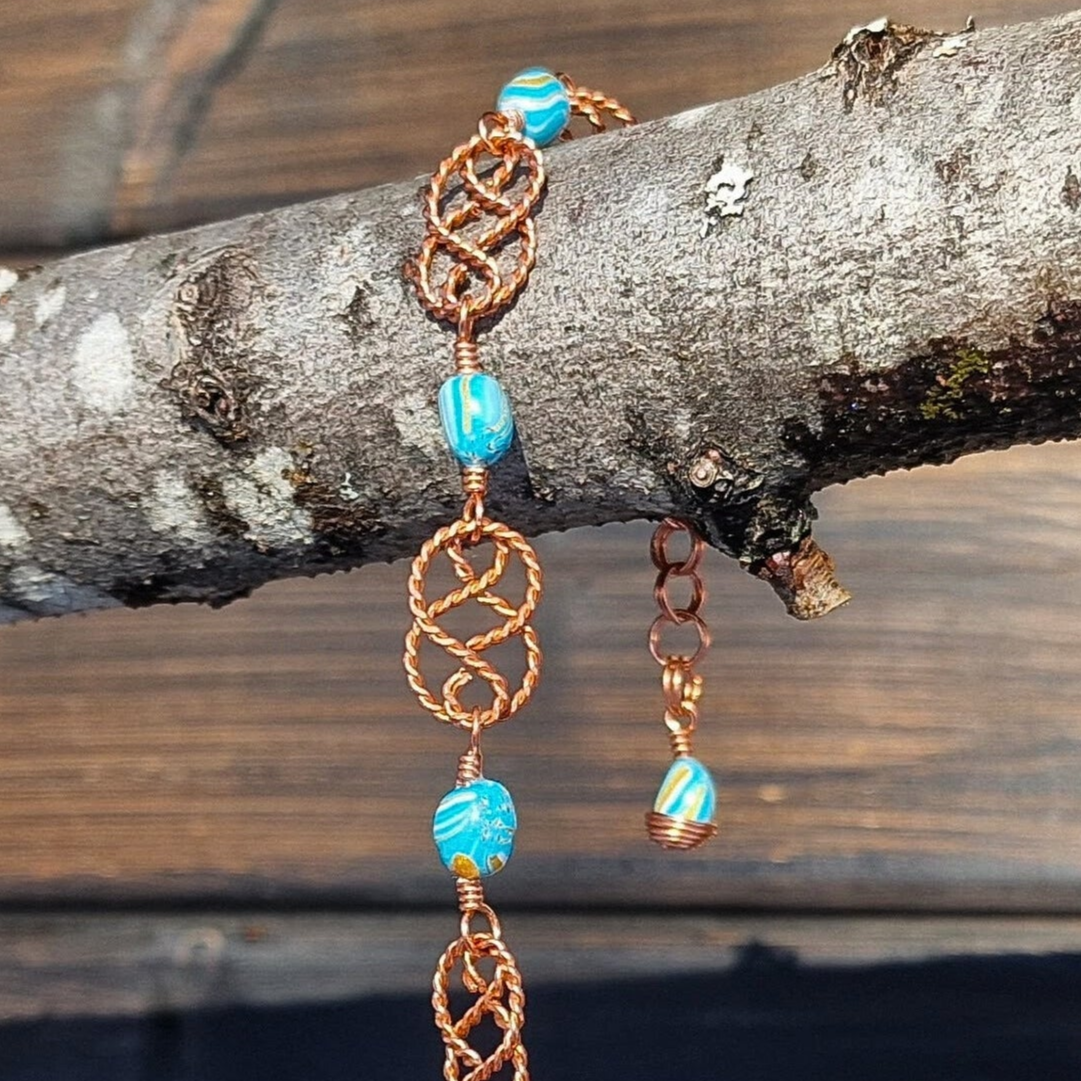 Armbånd med turkise perler og kobberdetaljer i tvunnet kobber
