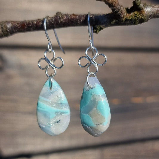 Øredobber i lyse pasteller og perlemorskimmer med firkløver detalj