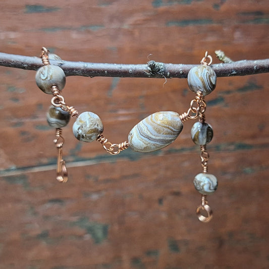 Armbånd med marmorerte polymer perler i bronse og hvit F