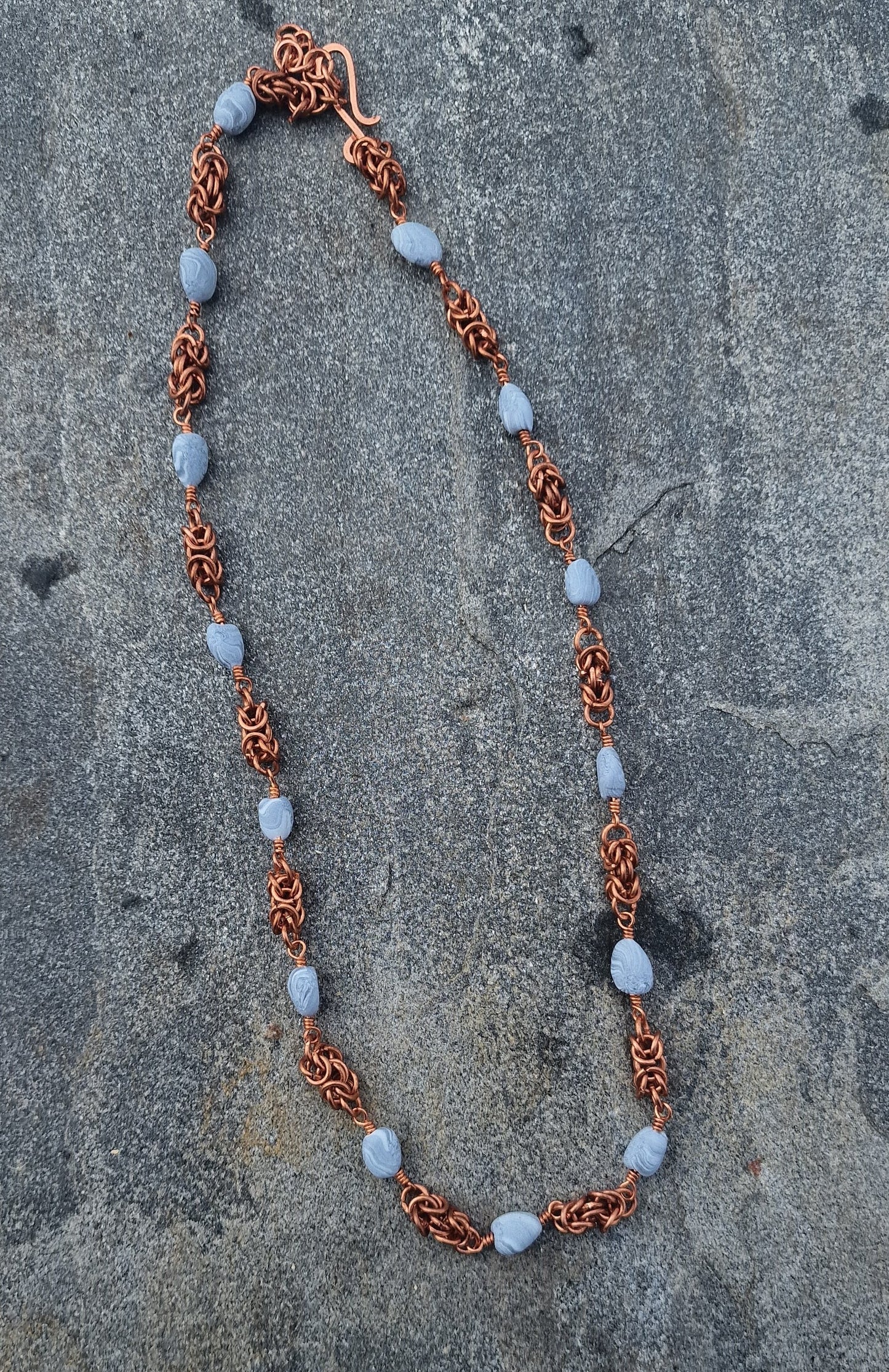 Halskjede med håndlagde perler og mellomstykker i kongelenke