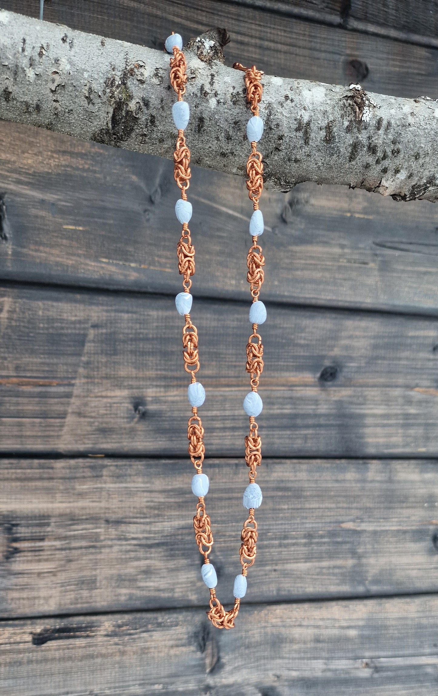 Halskjede med håndlagde perler og mellomstykker i kongelenke