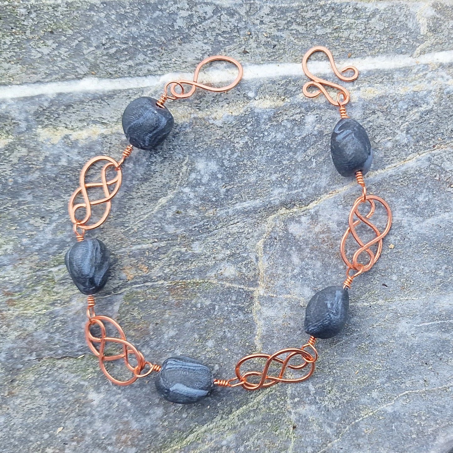 Keltisk inspirert kobberarmbånd med svarte perler med sølvmarmorering