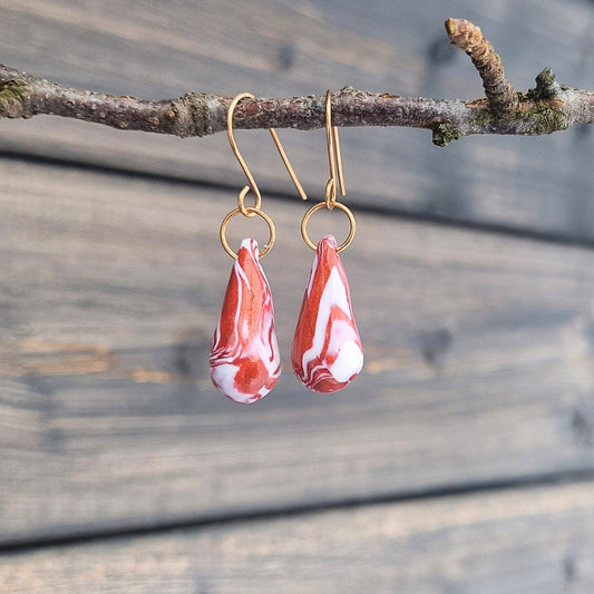 Øredobber i elegant rød og hvit marmorering og ørekroker i bronse