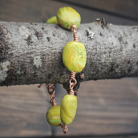 Armbånd med grønn og gullmarmorerte polymer perler