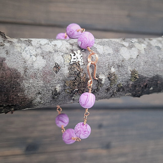 Armbånd med rosa marmorerte perler og kobber