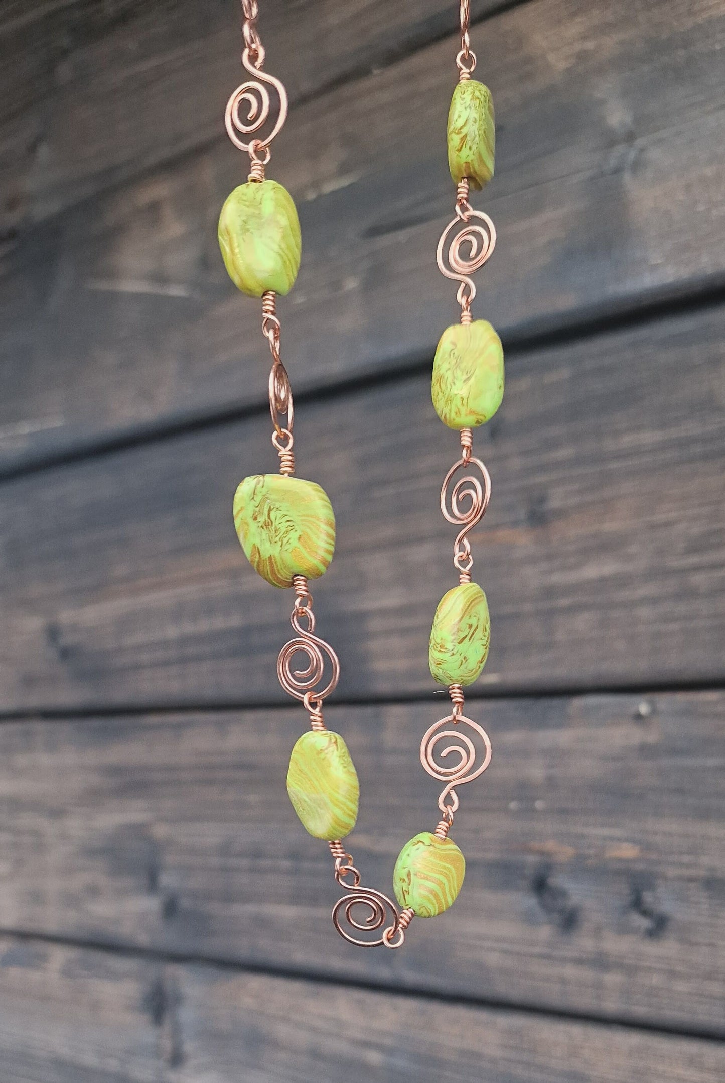 Smykke med store perler i grønn og gull med vakre kobberdetaljer