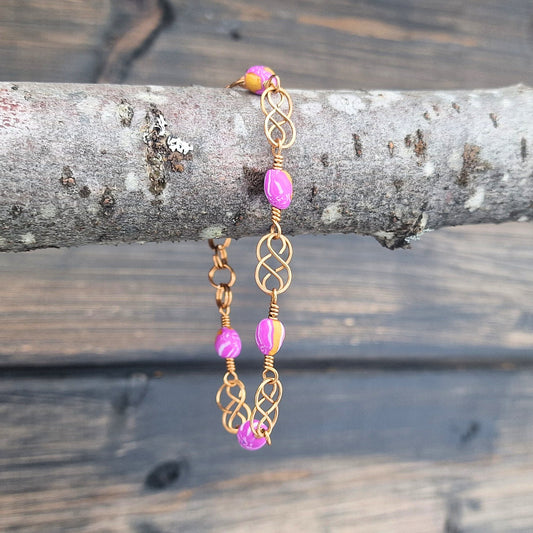 Armbånd med keltisk inspirert design i bronse og rosa polymer perler