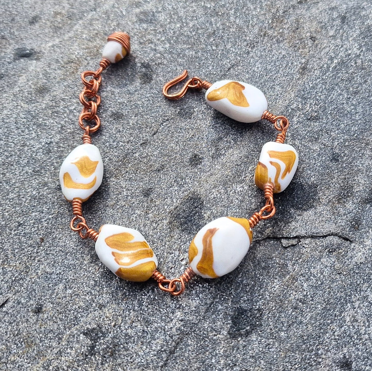 Armbånd med store håndformede perler i hvitt og gull