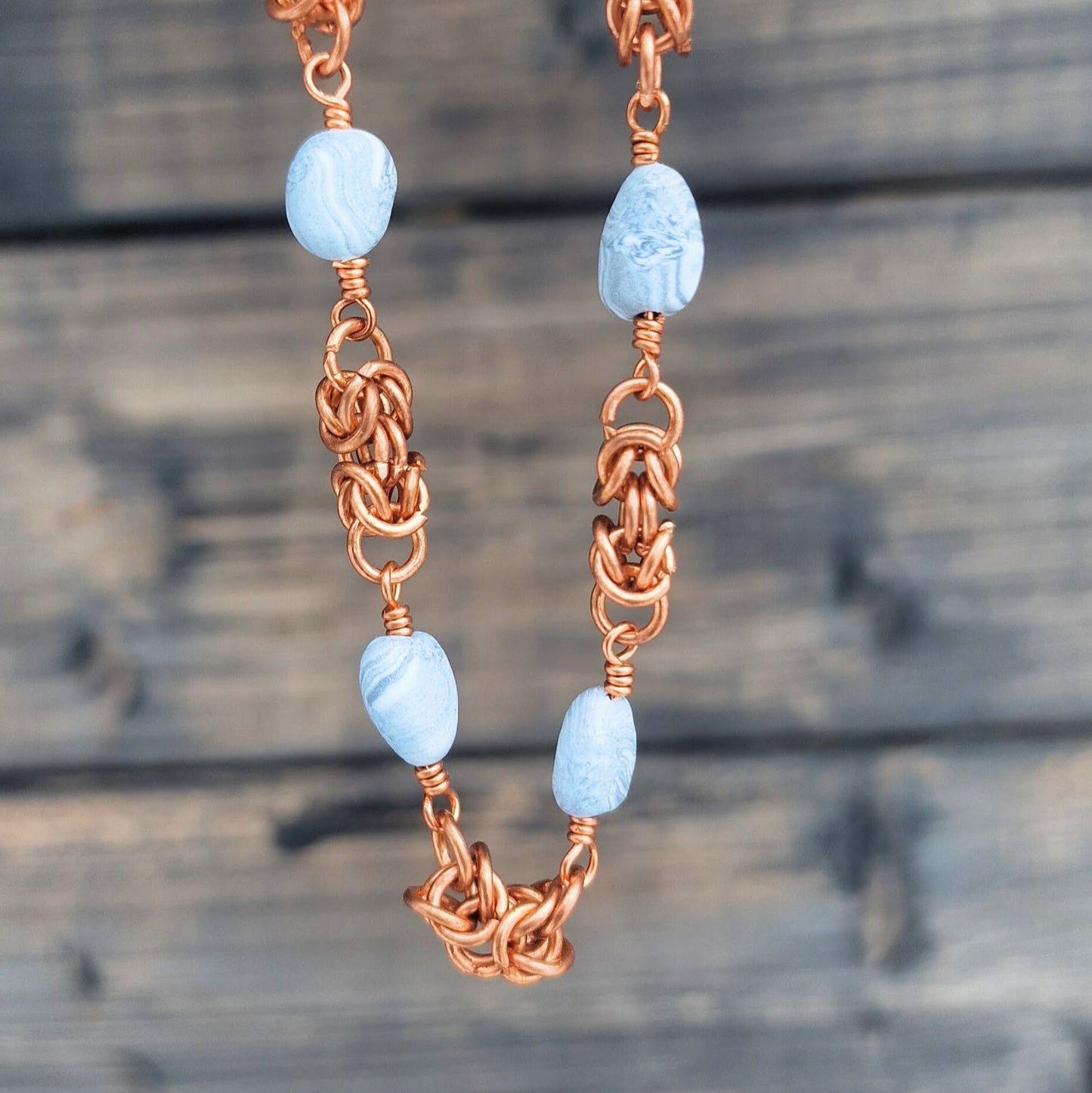 Halskjede med håndlagde perler og mellomstykker i kongelenke