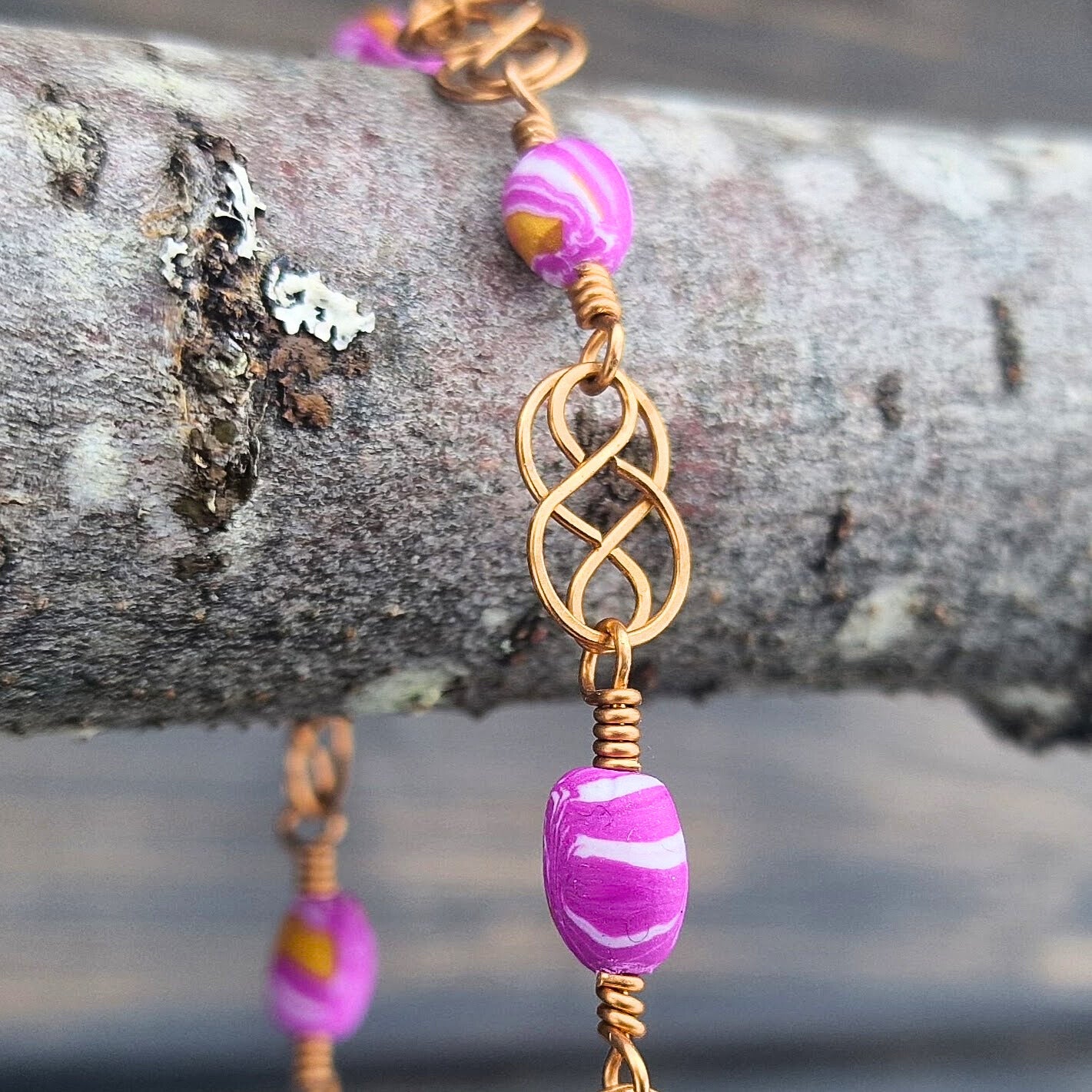 Armbånd med keltisk inspirert design i bronse og rosa polymer perler