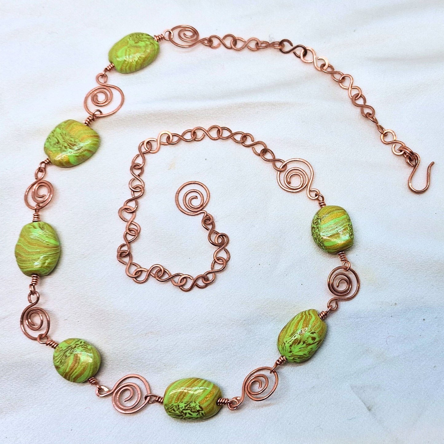 Smykke med store perler i grønn og gull med vakre kobberdetaljer
